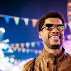 Mann mit Sonnenbrille auf einer Kirmes