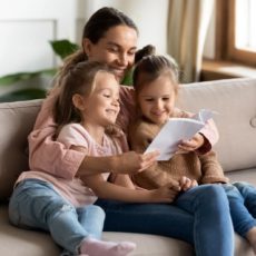 Haushaltshilfe liest Kindern etwas aus einem Buch vor