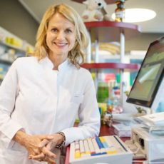 Apothekerin steht an der Kasse