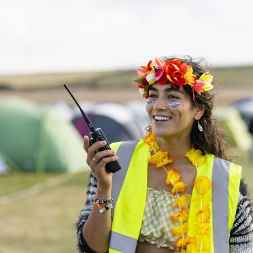 Eine Volunteer, die eine Warnweste trägt und auf einem Festival arbeitet