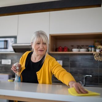 EIne Frau reinigt die Arbeitsfläche in der Küche
