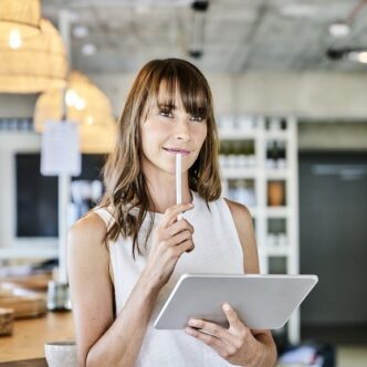 Thoughtful Woman Holding Digitized Pen And Digital Tablet While Standing Art Home